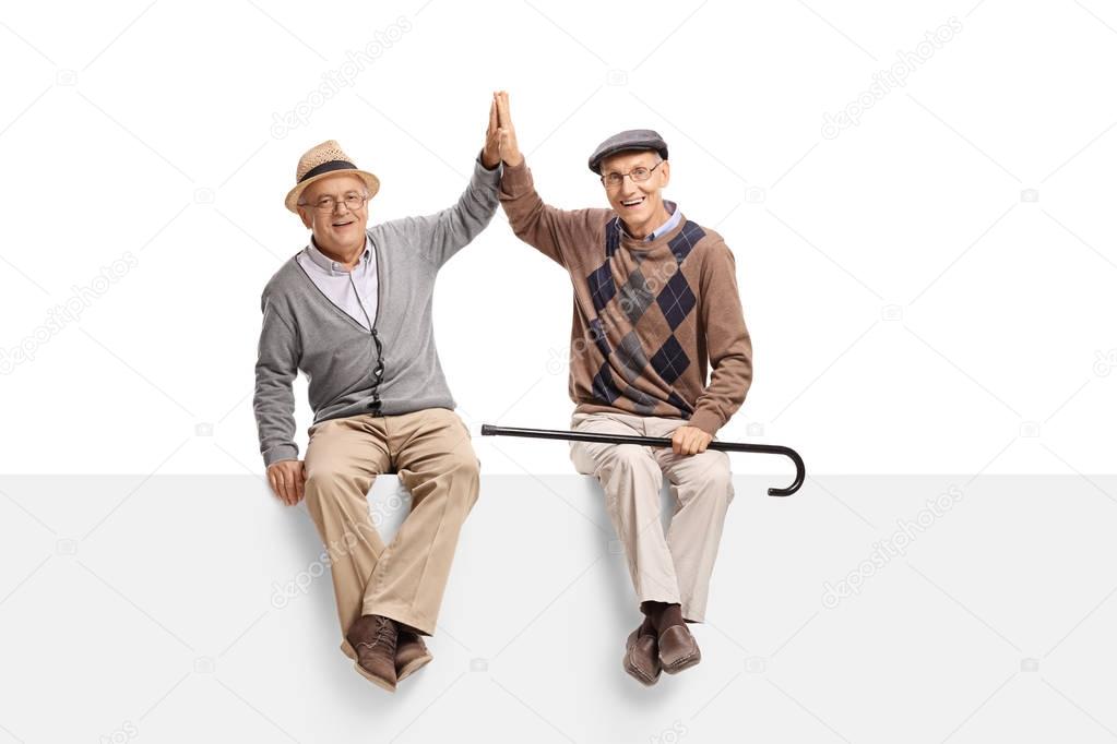 elderly men on a panel high-fiving each other