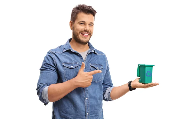 Hombre sosteniendo una pequeña papelera de reciclaje y señalando —  Fotos de Stock