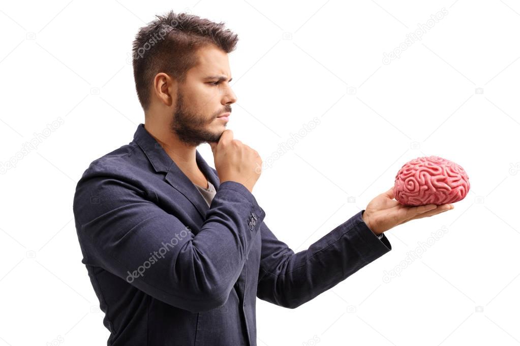 Pensive man looking at a brain model