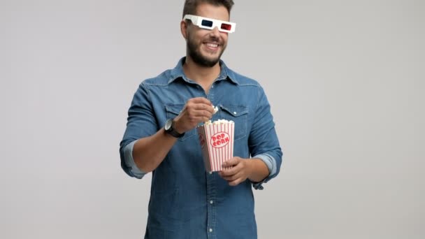 Хлопець в 3D окулярах їсть попкорн і сміється — стокове відео