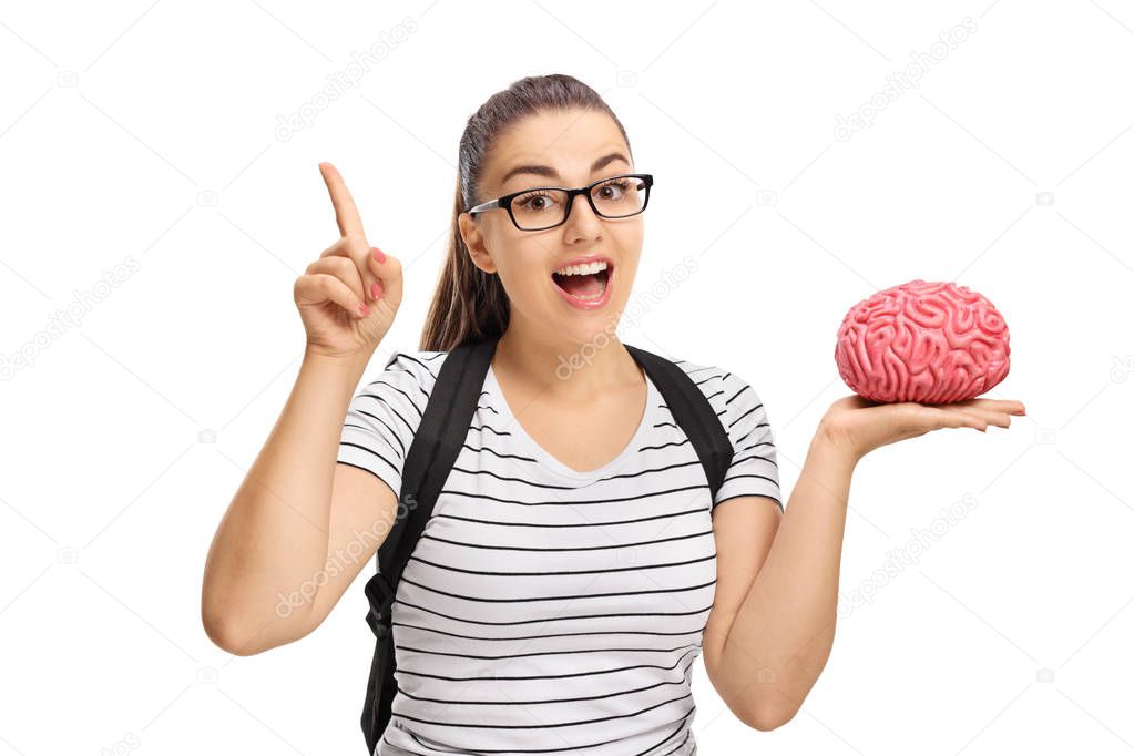 student holding a brain model and gesturing