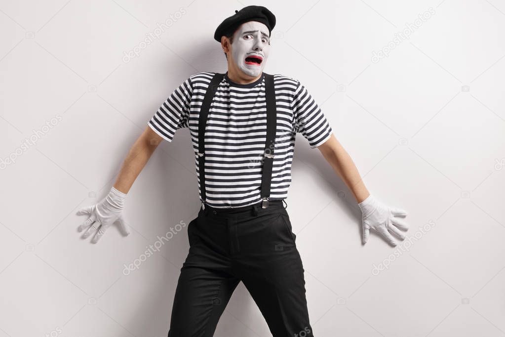 Terrified mime against a wall