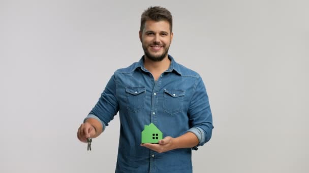 Чоловік тримає пару ключів і модельний будинок — стокове відео