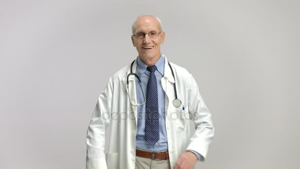 Oudere arts glimlachend en kruising zijn armen — Stockvideo