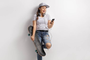 Bir telefon ve kaykay ile genç kız