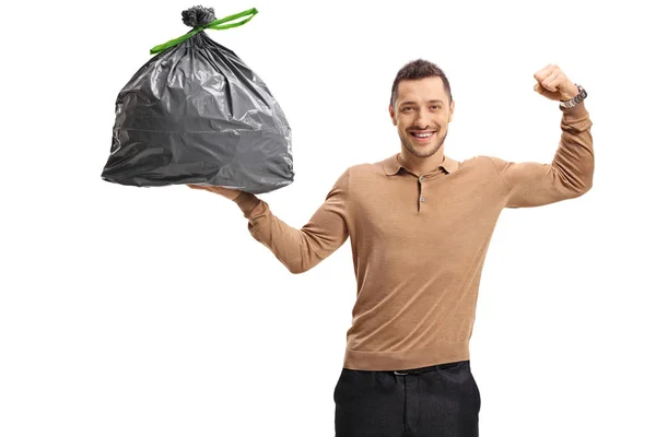 Muž drží pytle na odpadky a protahuje jeho biceps — Stock fotografie