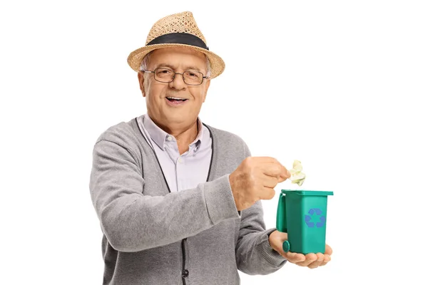 Senior throwing piece of garbage in a small recycling bin — Stock Photo, Image
