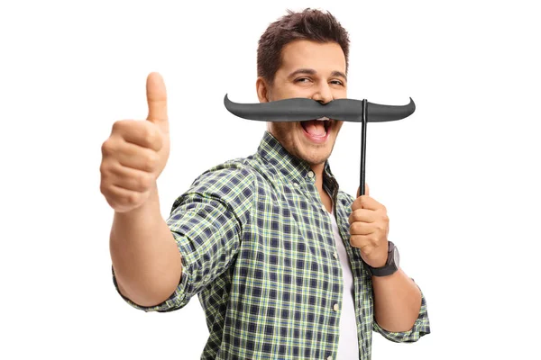 Tipo con bigote falso haciendo un gesto de pulgar hacia arriba — Foto de Stock