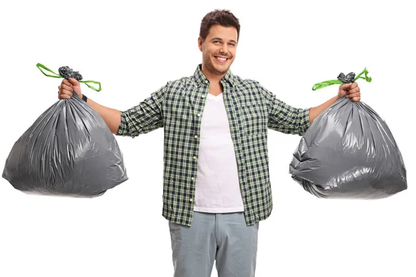 Jonge man met twee zakken vuilnis — Stockfoto
