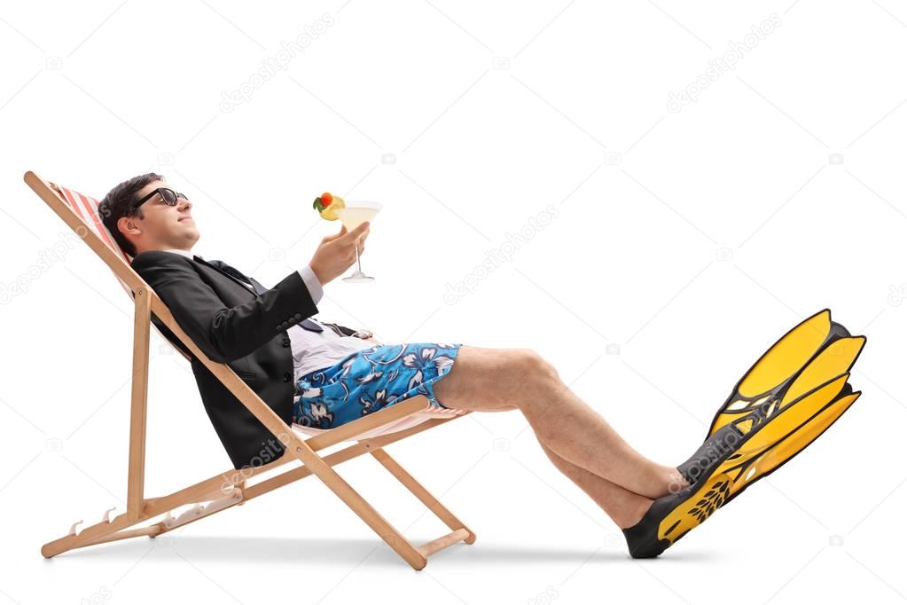 Businessman with swimming fins relaxing in a deck chair