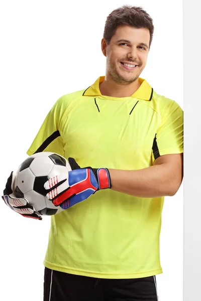 Goalkeeper with a football leaning against a wall — Stock Photo, Image