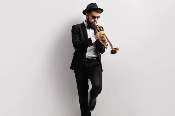 Trumpet player leaning against a wall — Stock Photo, Image