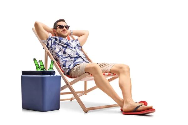 Tourist relaxing in a deck chair next to a cooling box — Stock Photo, Image