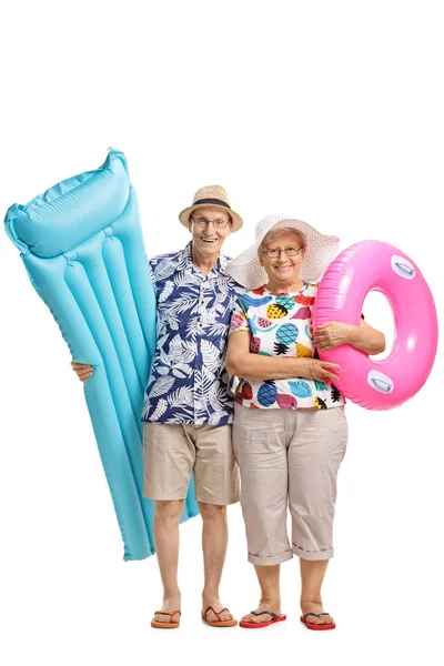 Пожилые люди с надувным матрасом и плавающей шиной — стоковое фото