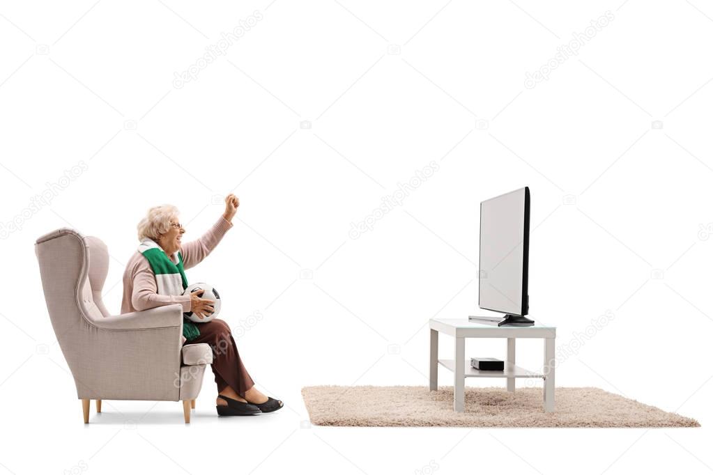 Elderly woman watching soccer on TV