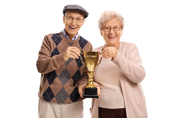 Homem idoso e mulher segurando um troféu de ouro — Fotografia de Stock