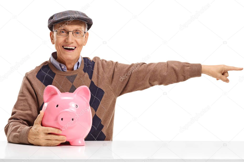Senior with a piggybank pointing right at a table