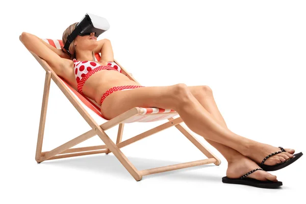 Kobieta z zestawem słuchawkowym Vr, leżąc na leżaku — Zdjęcie stockowe