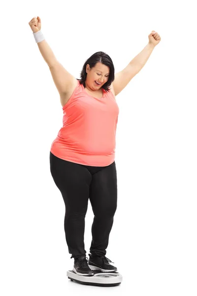 Overgewicht vrouw op een gewicht schaal gesturing geluk — Stockfoto