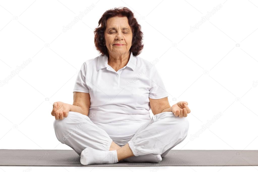 woman seated on an exercise mat meditating