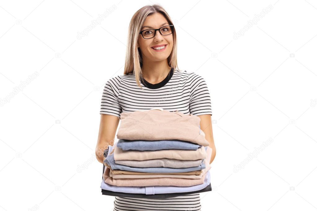 woman holding a pile of ironed and packed clothes