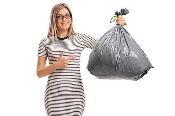 Mujer sosteniendo una bolsa de basura y señalando —  Fotos de Stock