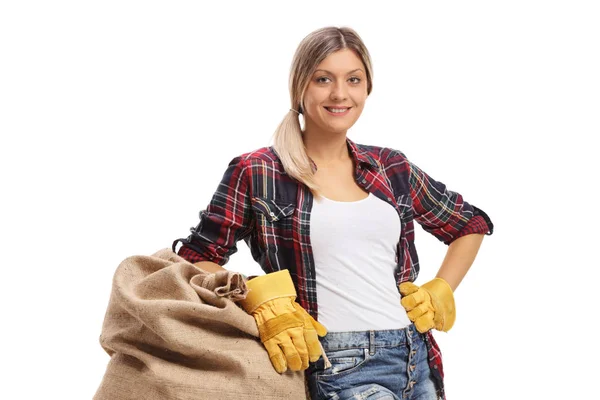 Female farmer leaning on a burlap sack — Stock Photo, Image