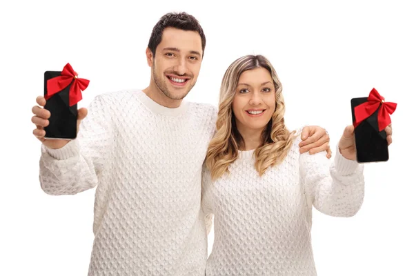 Paar zeigt mit Schleifen umwickelte Telefone als Geschenk — Stockfoto