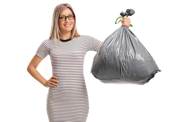 Mujer joven sosteniendo una bolsa de basura — Foto de Stock