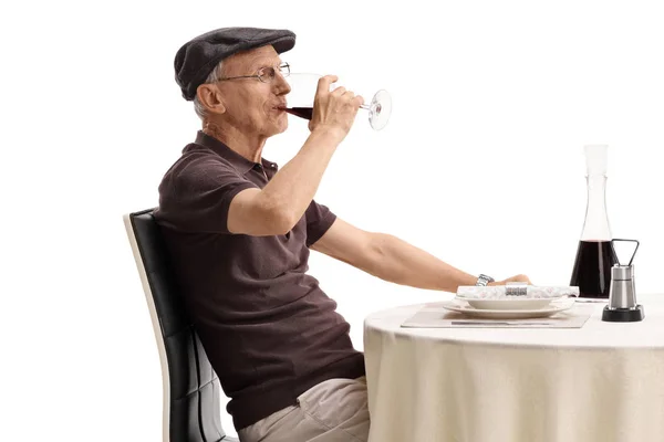 Senior zitten aan de tafel van een restaurant en het drinken van wijn — Stockfoto