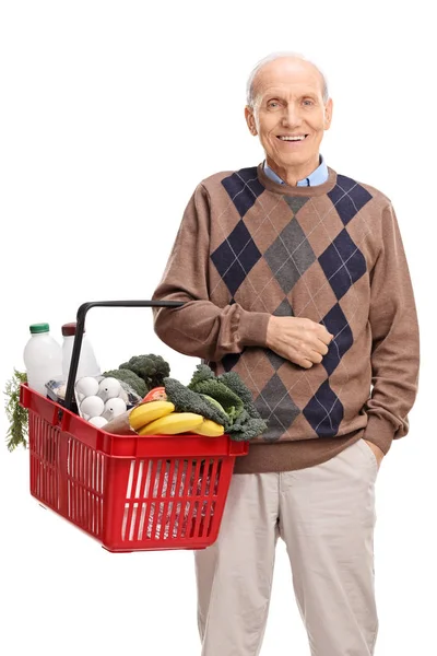 Homem segurando uma cesta de compras cheia de mantimentos — Fotografia de Stock