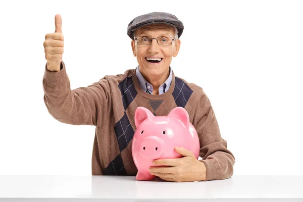Glada senior med piggybank göra en tumme upp skylt — Stockfoto