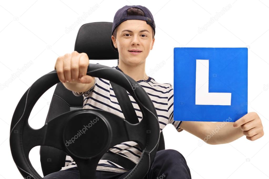 Teenage boy driving and showing an L-sign isolated on white background