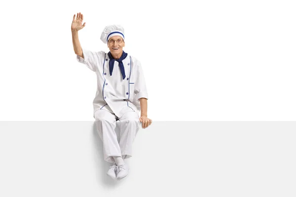 Chef sitting on a panel and waving at the camera — Stock Photo, Image