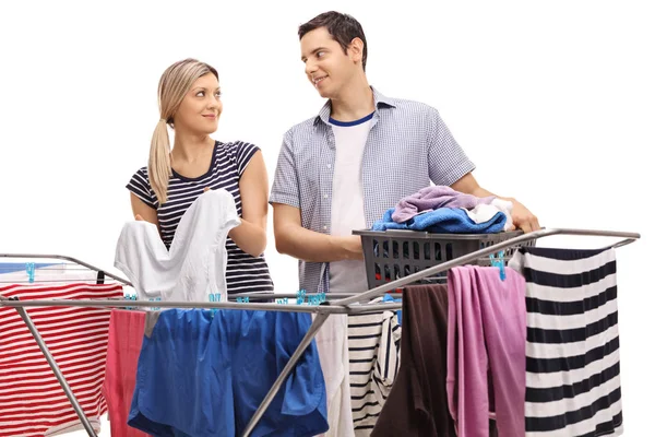 Couple hanging clothes on a rack dryer together — Stock Photo, Image