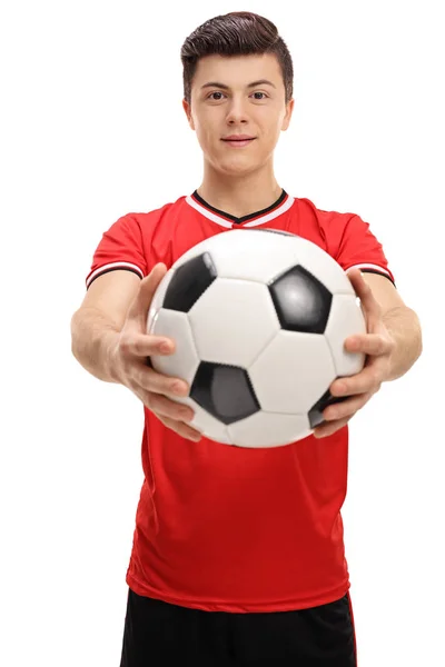 Joueur de football adolescent donnant un football — Photo