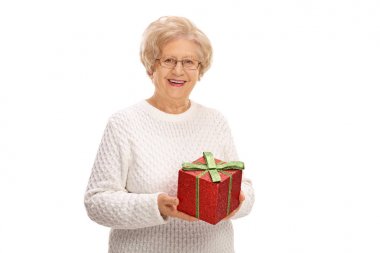 Bir hediye tutarak ve gülümseyen yaşlı kadın