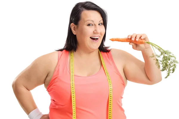 Избыточный вес женщины с измерительной лентой, имеющей морковь — стоковое фото