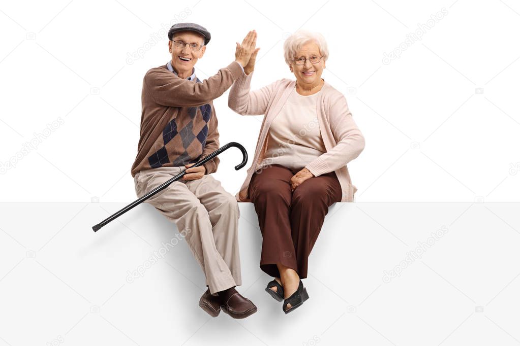 Elderly couple on panel high-fiving each other