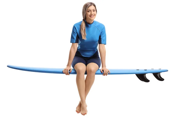 Junge Frau sitzt auf Surfbrett — Stockfoto