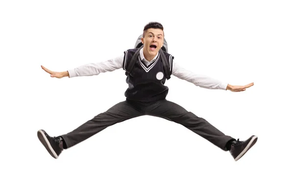 Overjoyed teenage student in a uniform jumping — Stock Photo, Image