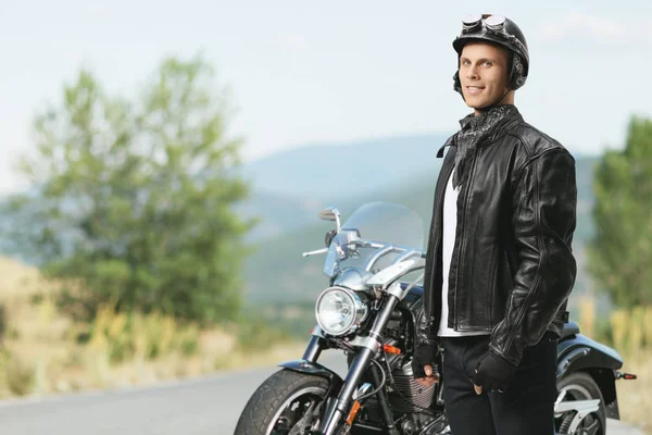 Biker in front of a motorcycle looking at the camera — Stock Photo, Image