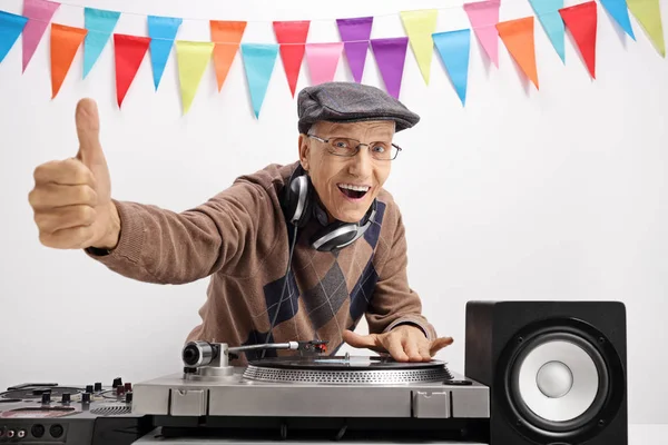 Senior spela musik på skivspelare och göra tummen upp skylt — Stockfoto