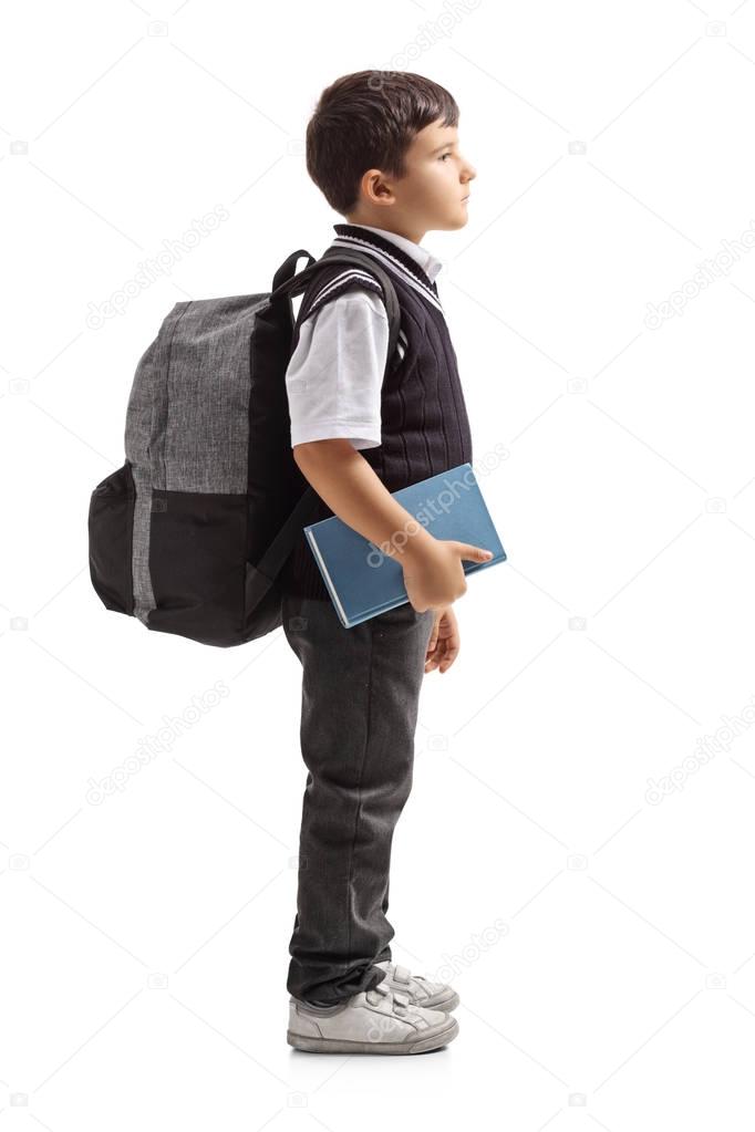 Small schoolboy with a backpack waiting in line
