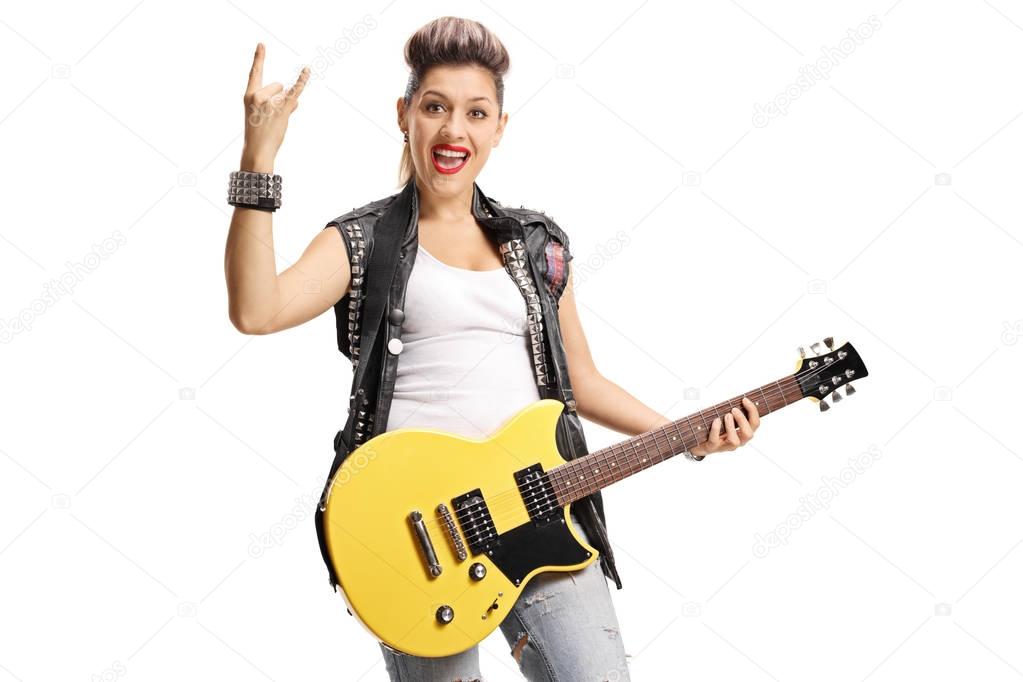 punk girl with an electric guitar making a rock hand gesture