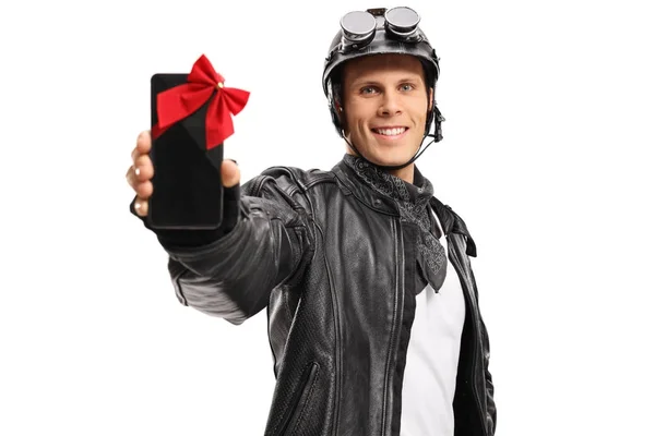 Motociclista mostrando un teléfono envuelto con una cinta como regalo — Foto de Stock