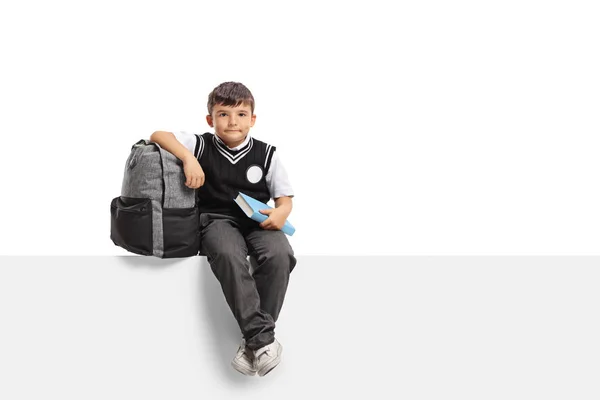 Школьник с рюкзаком и книгой на панели — стоковое фото