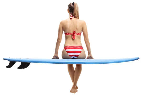 Mujer joven en bikini sentada en una tabla de surf — Foto de Stock