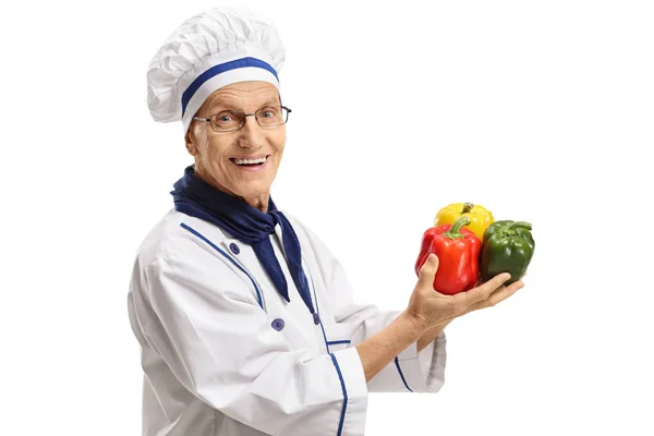 Elderly chef with peppers — Stock Photo, Image
