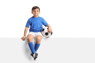 Bir panelde oturan küçük futbolcu